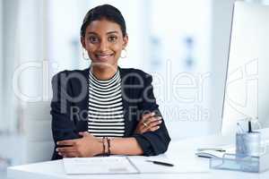 Positivity goes a long way in business. Portrait of an attractive young businesswoman posing at her office desk at work.