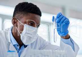 It has all come down to this. an unrecognizable male scientist holding up a test tube and examines it inside of a laboratory during the day.