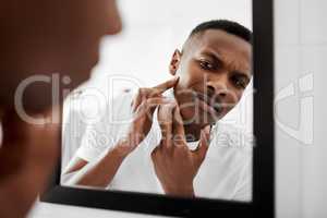 I dont want people to stare at it. a young man squeezing pimples in the bathroom mirror.