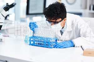 Theres a lot that happens in this lab. a young scientist using a dropper while working with samples in a lab.