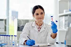 I might make a new breakthrough today. Closeup shot of an unrecognisable scientist writing notes while analysing samples in a lab.