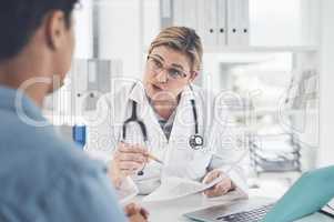 She aims to provide her patients with the best advice possible. an attractive young female doctor holding a document while having a discussion with a female patient in her office.