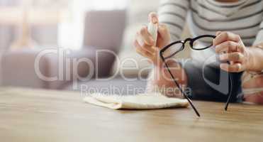 Clean regularly for a clear vision. an unrecognizable woman cleaning her reading glasses at home.