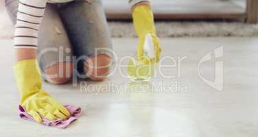 Getting rid of all those tough stains. a young woman cleaning her floors at home.