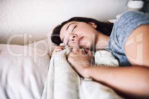 Enough sleep is a form of self-care. an attractive young woman sleeping on her bed in the morning at home.
