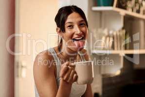 When the caffeine kicks in. a young woman enjoying a playful moment while having a cup of coffee at home.