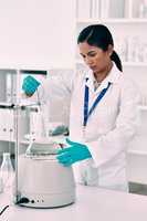Shes determined to obtain results. an attractive young female scientist working with a centrifuge and a conical flask in a laboratory.