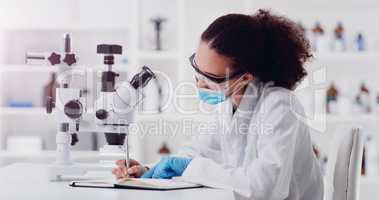 Contributing towards the sciences. a young scientist writing notes while using a microscope in a lab.