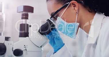 Science is filled with many mysteries. a young scientist using a microscope in a lab.