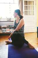 Yoga is the key to fitness. an attractive young woman sitting and holding a spinal half twist while doing yoga in her home.