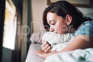 She woke up with a broken heart. an attractive young woman looking depressed while lying on her bed at home.