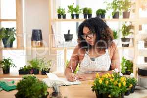 She takes are botany seriously. an attractive young female botanist making notes while working in her florist.