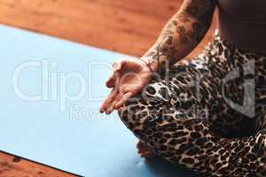 It only takes a few minutes every day to meditate. Closeup shot of a woman meditating on a yoga mat at home.