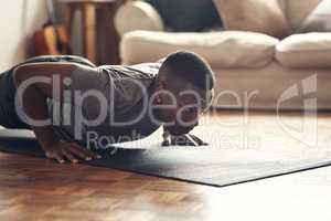 You have to be fearless in order to achieve results. a sporty young man doing push up exercises at home.