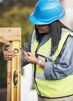 Marking off each spot with precision. an attractive young female construction worker working on site.