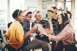 Cheers to the most wonderful time of the year. a group of cheerful young friends making a toast while celebrating Christmas together at home.