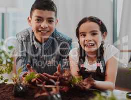 Things tend to get a little dirty over here. Cropped portrait of two adorable young siblings smiling while doing some gardening at home.