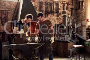 Were the heavy metal guys. two handsome young metal workers working together inside a welding workshop.