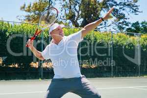 Another game won. a handsome mature man celebrating a win while playing tennis during the day.