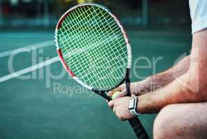 Today I will advance to a new level. Closeup shot of an unrecognisable man holding a tennis racket and ball on a tennis court.