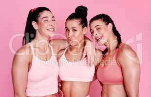 Becoming strong and beautiful women. Studio portrait of a group of sporty young women standing together against a pink background.