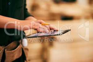 Designing furniture has never been this easy. a an unrecognizable carpenter using a digital tablet in her workshop.