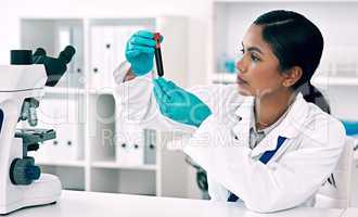 I need to find out whats in this blood. an attractive young female scientist inspecting a test tube filled with a blood sample while working in a laboratory.