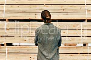 Ive got plenty of options to choose from. Rearview shot of young carpenter looking at a piles of wood inside a workshop.