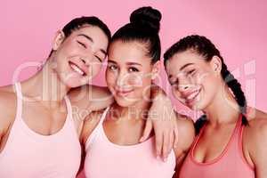 Life might be tough but so are we. Studio portrait of a group of sporty young women standing together against a pink background.