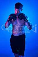 Nothing is given to you, you have to take it. Blue filtered shot of a sportsman wearing boxing gloves while posing in the studio.