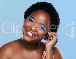 A beautiful smile and personality to match. Studio shot of a beautiful young woman posing against a blue background.