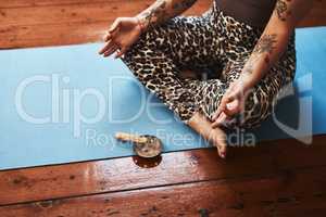 Cleansing the space around her to promote deep relaxation. Closeup shot of a woman burning a palo santo stick while meditating on a yoga mat at home.