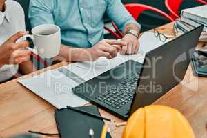 Time to get another project started. Closeup shot of two architects working together on a laptop in an office.