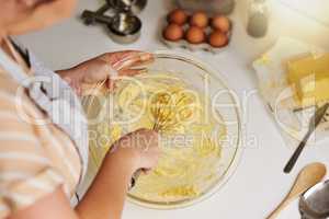 This recipe is better than anything youve ever tasted. an unrecognizable woman mixing batter in a glass bowl.