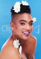 Flowers are never a bad idea. Portrait of a gender fluid young man posing with flowers on his head against a blue background.
