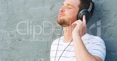 Let the rhythm takeover. a handsome young man listening to music on his headphones outdoors.