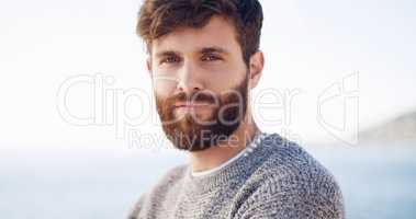 Theres just something about him, maybe its his beard. a handsome young man spending the day at the beach.