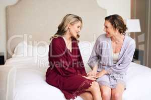 Im so excited about being your maid of honour. a beautiful young bride having a chat with her best friend in their dressing room before the wedding.