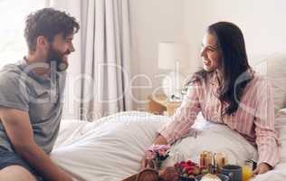 If he brings you food, hes a keeper. a happy young couple enjoying breakfast in bed together at home.