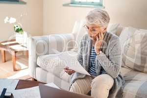 Nothing is more destructive than debt. a senior woman looking stressed while going through paperwork at home.