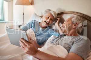 I remember this day as if it was yesterday. a happy senior couple sitting together in bed and using a tablet in a nursing home.