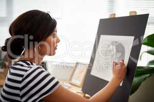 Attention to detail is the secret. an attractive young artist drawing a portrait of a woman inside her studio.