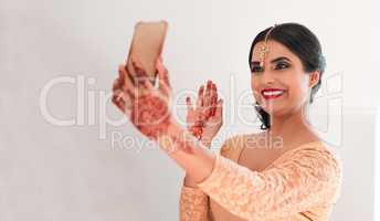 Some pre wedding customs are becoming more modern. a young woman waving while using a smartphone on her wedding day.