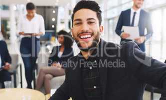 I smile my way through challenges. Cropped portrait of a handsome young businessman sitting and smiling while his colleagues work behind him in the office.