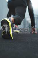 The aim is to beat your excuses in this race. Closeup shot of a sporty man in starting position while exercising outdoors.