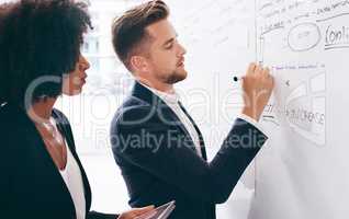 Company success requires skilful strategising. a young businessman and businesswoman having a brainstorming session in a modern office.