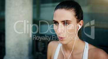 Music to get her in the workout mood. a young woman listening to music during her workout in the city.