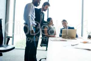 Teamwork, trust and good leadership during a meeting while using a laptop for innovation and marketing research in an office. Corporate and motivated businesspeople discussing their company vision