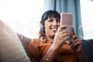 I wonder where this link will take me. a young woman wearing headphones while using her cellphone at home.