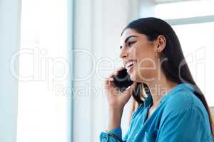 Sounds like an opportunity I cant pass. a young businesswoman talking on a cellphone in an office.